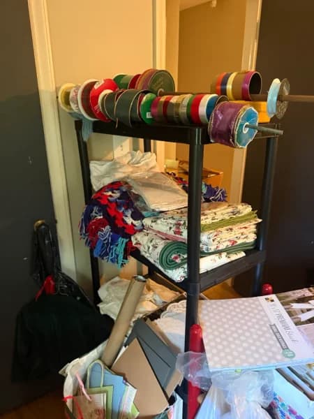 Black metal mobile ribbon storage rack with multiple spool rods